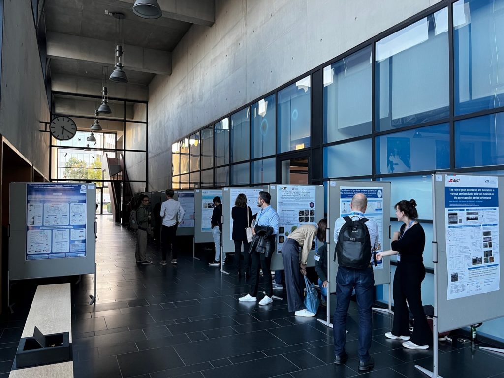 Researchers present their posters in a large open corridor