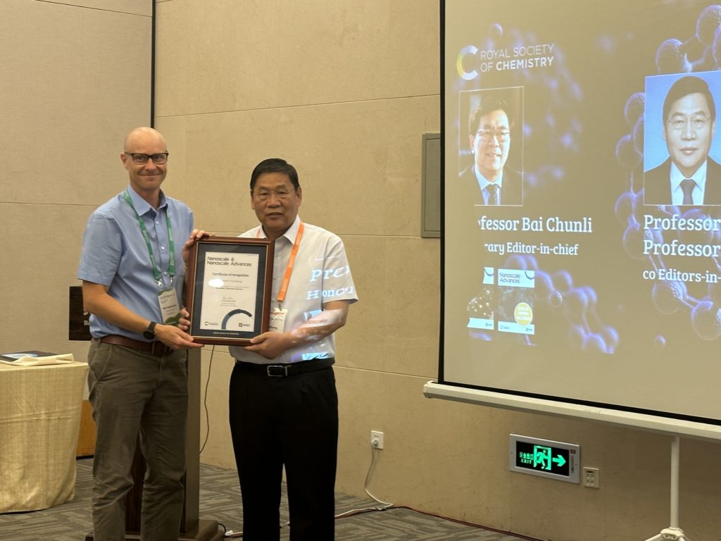 Publisher Dr Neil Hammond presents Prof Yue Zhang with a certificate of recognition from the journals Nanoscale and Nanoscale advances.