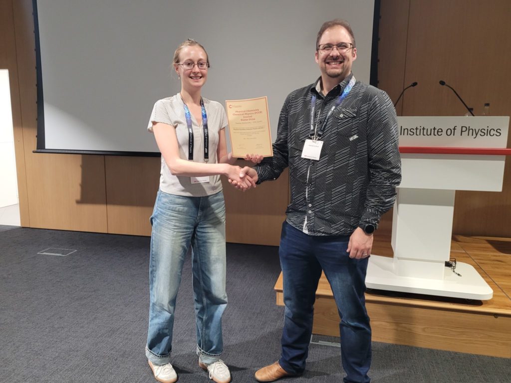 Taieesa Peshkovsky (left) being awarded a poster prize by event organizer Guido Bolognesi (right)