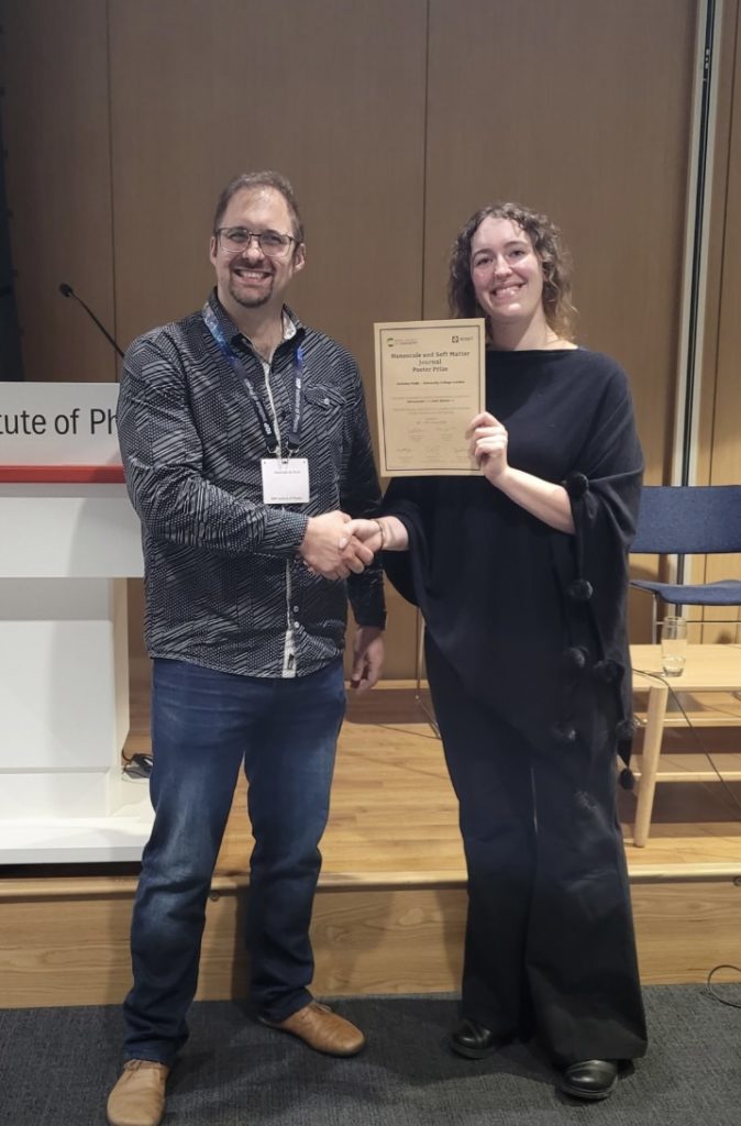 Guido Bolognesi (left) awarding the poster prize to Christina Puijk (right)